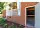 Brick house exterior showcasing an open door to a utility area and a covered patio at 1975 Oakridge Duncan Rd, Fuquay Varina, NC 27526