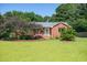 Charming brick home featuring a well-manicured lawn and mature trees, creating a welcoming curb appeal at 1975 Oakridge Duncan Rd, Fuquay Varina, NC 27526