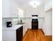 Bright kitchen features white cabinets, stainless steel appliances and hardwood floors at 1975 Oakridge Duncan Rd, Fuquay Varina, NC 27526