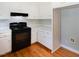 Kitchen has black range, white cabinets with gold knobs, and light countertops at 1975 Oakridge Duncan Rd, Fuquay Varina, NC 27526
