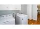Bright laundry room includes a washing machine, dryer, and white storage cabinets at 1975 Oakridge Duncan Rd, Fuquay Varina, NC 27526