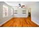 Sunlit living room with hardwood floors, a ceiling fan, and multiple windows at 1975 Oakridge Duncan Rd, Fuquay Varina, NC 27526