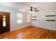Bright living room with hardwood floors, floating shelves and large windows at 1975 Oakridge Duncan Rd, Fuquay Varina, NC 27526