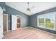 Bedroom featuring a blue accent wall, ceiling fan, a window, and light wood-look flooring at 2101 Piney Brook Rd # 102, Raleigh, NC 27614