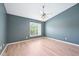 Bedroom featuring blue accent wall, ceiling fan, large window and light wood-look flooring at 2101 Piney Brook Rd # 102, Raleigh, NC 27614