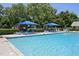 Relaxing community pool with lounge chairs and umbrellas at 2101 Piney Brook Rd # 102, Raleigh, NC 27614
