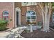 A welcoming front porch with beautiful landscaping, including a birdbath, and flowering plants at 2101 Piney Brook Rd # 102, Raleigh, NC 27614