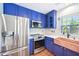 Updated kitchen featuring stainless steel appliances, granite counters, and blue cabinets at 2101 Piney Brook Rd # 102, Raleigh, NC 27614