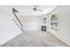 Well-lit living room with a fireplace, carpet flooring, a ceiling fan and a staircase nearby at 2101 Piney Brook Rd # 102, Raleigh, NC 27614