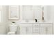 Bright bathroom featuring a double vanity with white cabinets, modern fixtures, and a framed art piece at 211 Tennyson Dr, Garner, NC 27529