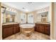 Luxurious bathroom featuring a soaking tub, dual vanities, granite countertops, and stylish fixtures at 2129 Glade Valley Ln, Morrisville, NC 27560