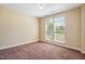 Empty bedroom with neutral walls, carpet flooring, and a window providing natural light at 2129 Glade Valley Ln, Morrisville, NC 27560