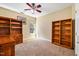 Inviting bedroom featuring built-in bookshelves, a ceiling fan, and ample natural light from the window at 2129 Glade Valley Ln, Morrisville, NC 27560