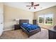 Comfortable bedroom with neutral carpet, ample windows, ceiling fan, and coordinated furniture at 2129 Glade Valley Ln, Morrisville, NC 27560