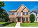 Charming brick two-story home with manicured lawn, decorative columns, and inviting front porch at 2129 Glade Valley Ln, Morrisville, NC 27560