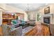 Cozy living room featuring hardwood floors, stone fireplace, comfortable seating, and seamless flow to the kitchen at 2129 Glade Valley Ln, Morrisville, NC 27560