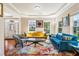 Sun-lit living room featuring hardwood floors, modern furniture, tray ceiling, and large windows at 2129 Glade Valley Ln, Morrisville, NC 27560