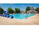 Community swimming pool with lounge chairs and umbrellas, surrounded by trees at 2129 Glade Valley Ln, Morrisville, NC 27560