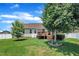 Well-manicured backyard with a large lawn, mature trees, deck, and privacy fence at 22 Evie Dr, Smithfield, NC 27577