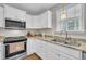 Bright kitchen features granite countertops, stainless steel appliances, and white cabinets at 22 Evie Dr, Smithfield, NC 27577