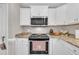 Close-up of modern stainless steel stove and granite countertops in bright kitchen at 22 Evie Dr, Smithfield, NC 27577