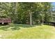 Expansive backyard featuring a deck, lush green lawn, and mature trees at 23 Northern Way Ct, Durham, NC 27712