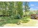 Lush backyard with mature trees, green lawn, and a view of the surrounding nature at 23 Northern Way Ct, Durham, NC 27712