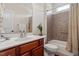 A bathroom features a shower with brown tiles and a sink with wood cabinets and white counter at 23 Northern Way Ct, Durham, NC 27712