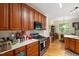 Bright kitchen open to dining area with wooden cabinets, stainless steel appliances, and marble countertops at 23 Northern Way Ct, Durham, NC 27712