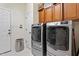 Well-equipped laundry room featuring a modern washer and dryer, with convenient overhead storage cabinets at 23 Northern Way Ct, Durham, NC 27712
