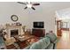 This living room features a fireplace, hardwood floors, natural light, and a ceiling fan for optimal comfort at 23 Northern Way Ct, Durham, NC 27712