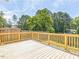 A wooden deck with railing overlooks the large, lush backyard at 2300 Radius Cir, Sanford, NC 27330