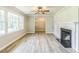 Bright living room boasts laminate floors, large windows, and a cozy fireplace with a white mantle at 2300 Radius Cir, Sanford, NC 27330
