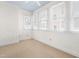 Well-lit bedroom with multiple windows, exposed brick, and neutral carpet creating a cozy and inviting atmosphere at 235 Mccauley St # D, Chapel Hill, NC 27516