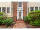 Charming brick building with white trim, a glass front door, and professional landscaping creates an inviting entrance at 235 Mccauley St # D, Chapel Hill, NC 27516