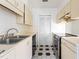 Galley-style kitchen featuring white cabinets, black appliances, and unique flooring at 235 Mccauley St # D, Chapel Hill, NC 27516