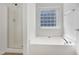 Bathroom with a shower, tub, and glass block window at 238 Royal Tower Way, Cary, NC 27513
