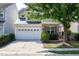 Charming home featuring a stone facade, a two-car garage, and a beautifully landscaped front yard with mature trees at 238 Royal Tower Way, Cary, NC 27513