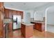 Bright kitchen with stainless steel appliances, a center island, and wooden cabinetry for a functional cooking space at 238 Royal Tower Way, Cary, NC 27513
