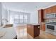 Bright kitchen with stainless appliances, wooden cabinets, and a central island near a dining area filled with natural light at 238 Royal Tower Way, Cary, NC 27513