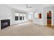 Bright living room with a fireplace and multiple windows, seamlessly connected to the kitchen through arched entryways at 238 Royal Tower Way, Cary, NC 27513