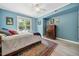 Light-filled bedroom with blue walls, a ceiling fan, hardwood floors and a beautiful rug at 2603 Stafford Ave # Apt C, Raleigh, NC 27607
