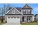 Charming two-story home with gray siding, black shutters, and a two-car garage at 269 Tennyson Dr, Garner, NC 27529