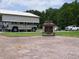 Shot of backyard with outdoor fireplace, lawn, a covered parking area, and several parked vehicles at 2817 Buckboard Ln, Raleigh, NC 27603