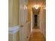 Hallway with hardwood flooring featuring white trim and walls painted in a soft yellow hue at 2817 Buckboard Ln, Raleigh, NC 27603