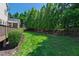 This lush green backyard with tall hedges and mature trees offers privacy and tranquility at 307 Beacon Falls Ct, Cary, NC 27519