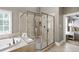 Luxurious bathroom featuring double shower, soaking tub, and tiled walls at 307 Beacon Falls Ct, Cary, NC 27519