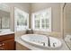 Bright bathroom featuring garden tub and window at 307 Beacon Falls Ct, Cary, NC 27519