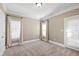 Spacious bedroom with plush carpeting, two large windows, and access to the outside at 307 Beacon Falls Ct, Cary, NC 27519