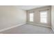 This bedroom has neutral walls, carpeted floors, and plenty of natural light from the two windows at 307 Beacon Falls Ct, Cary, NC 27519